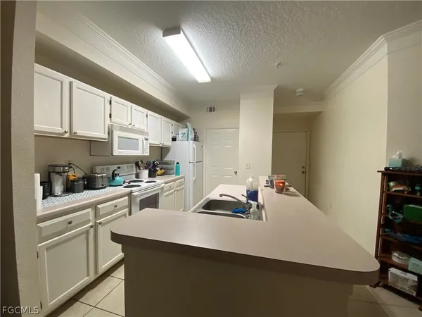 a kitchen with cabinets a sink a stove and white cabinets