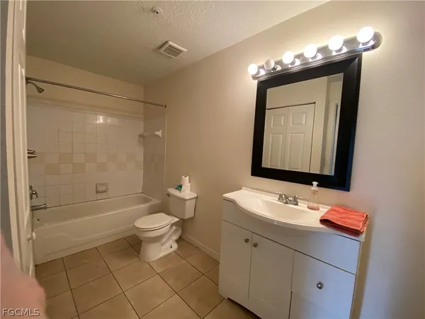a bathroom with a toilet a sink a mirror and a shower