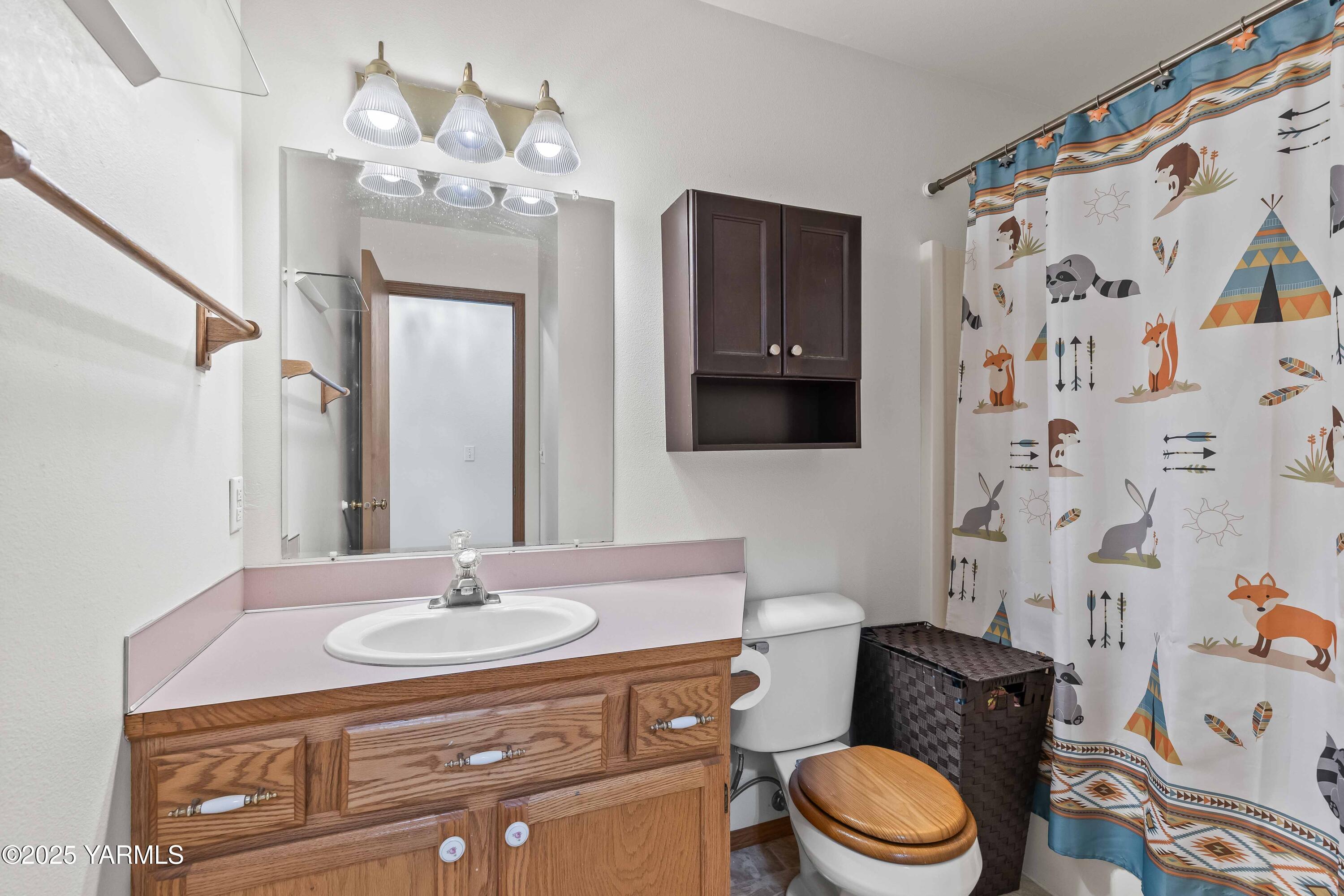 6508 Terry Avenue Yakima, WA 98908 - Photo 21 of 24 a bathroom with a granite countertop sink a toilet and a mirror