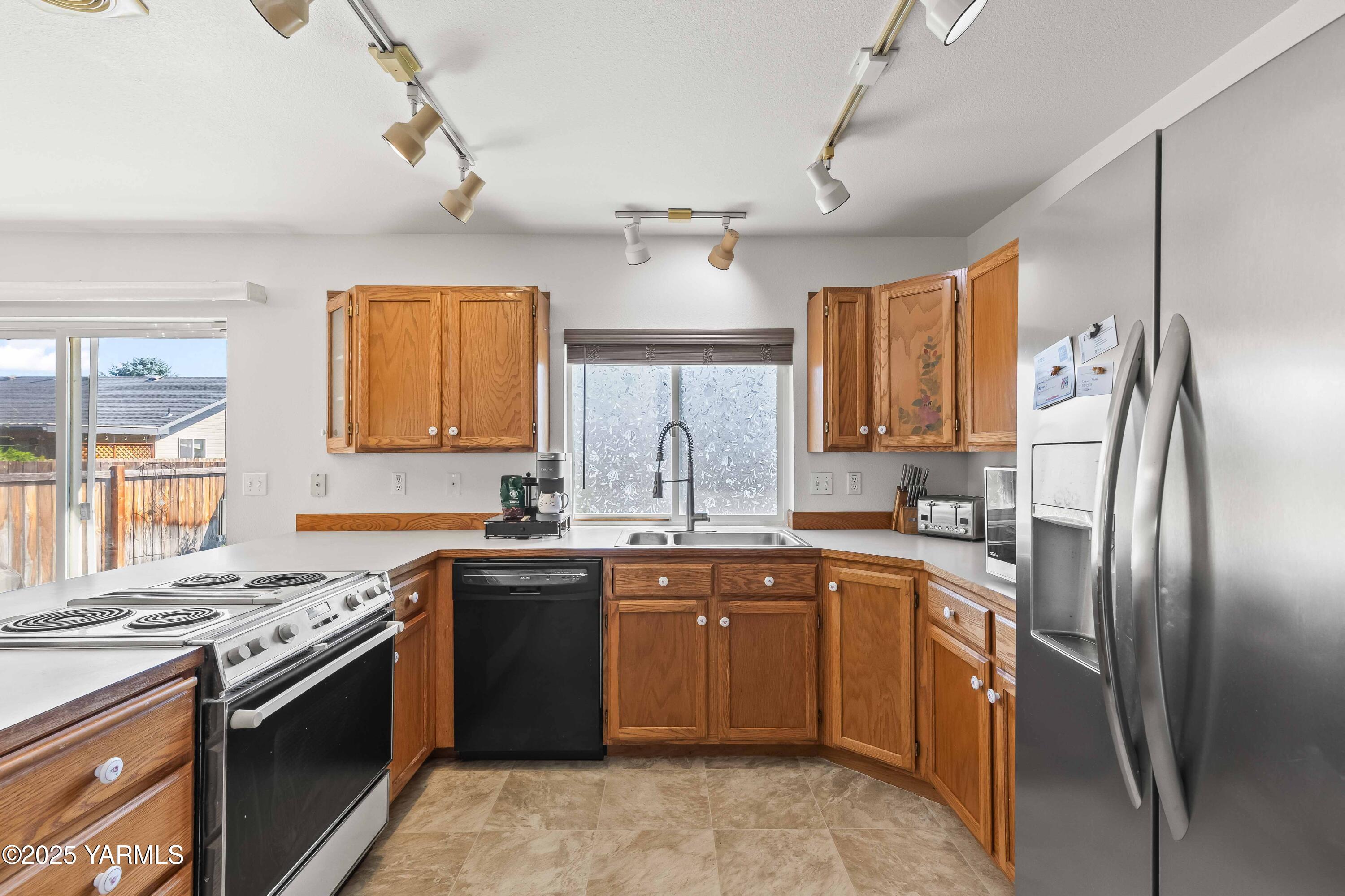 6508 Terry Avenue Yakima, WA 98908 - Photo 9 of 24 a kitchen with stainless steel appliances granite countertop a sink stove and refrigerator