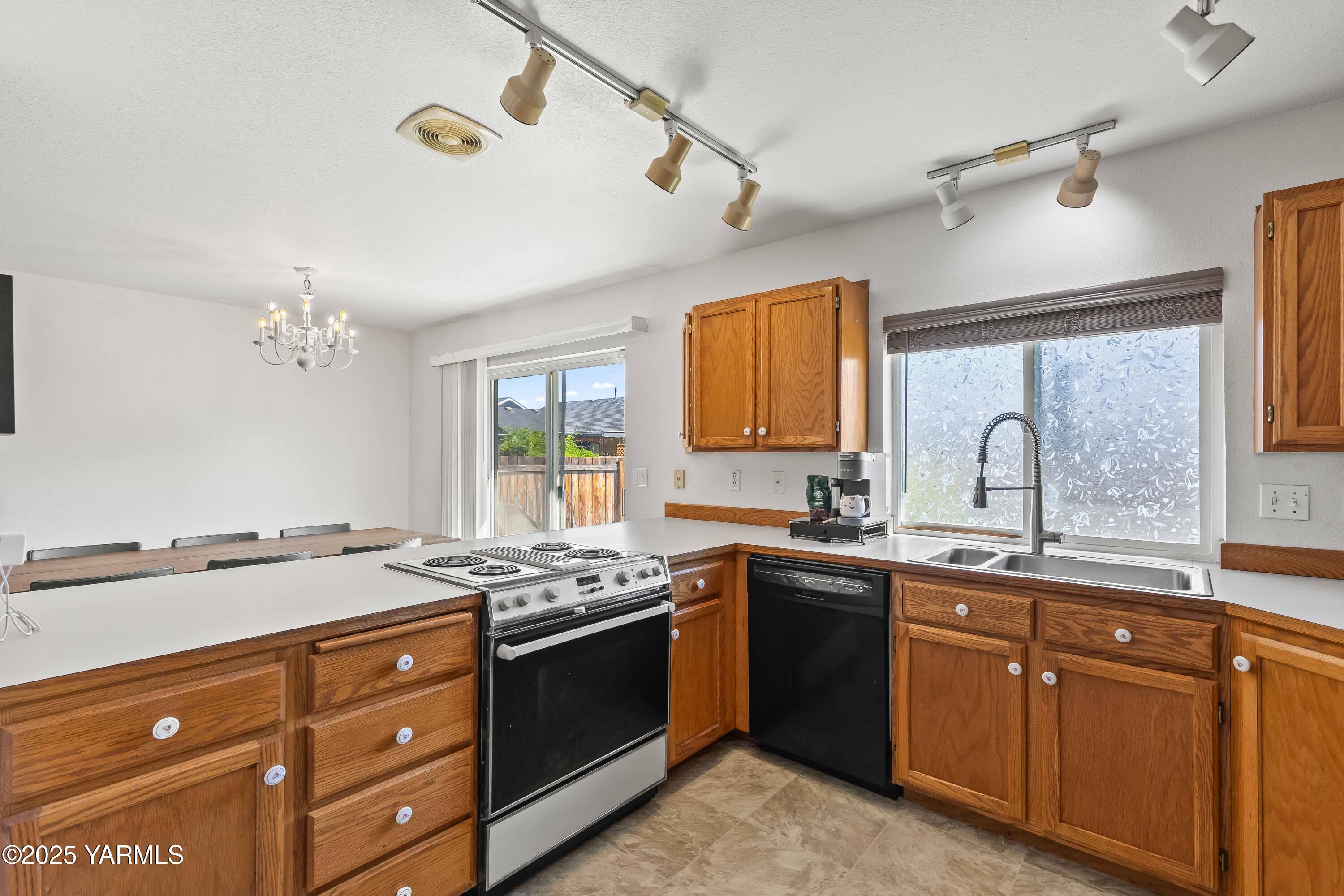 6508 Terry Avenue Yakima, WA 98908 - Photo 10 of 24 a kitchen with granite countertop a sink stove and cabinets