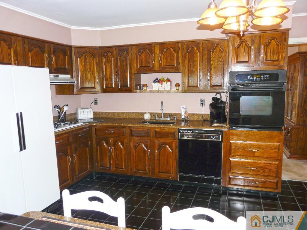 90 Drake Road Somerset, NJ 08873 - Photo 7 of 20 a kitchen with granite countertop a stove a sink dishwasher and a microwave oven with cabinets
