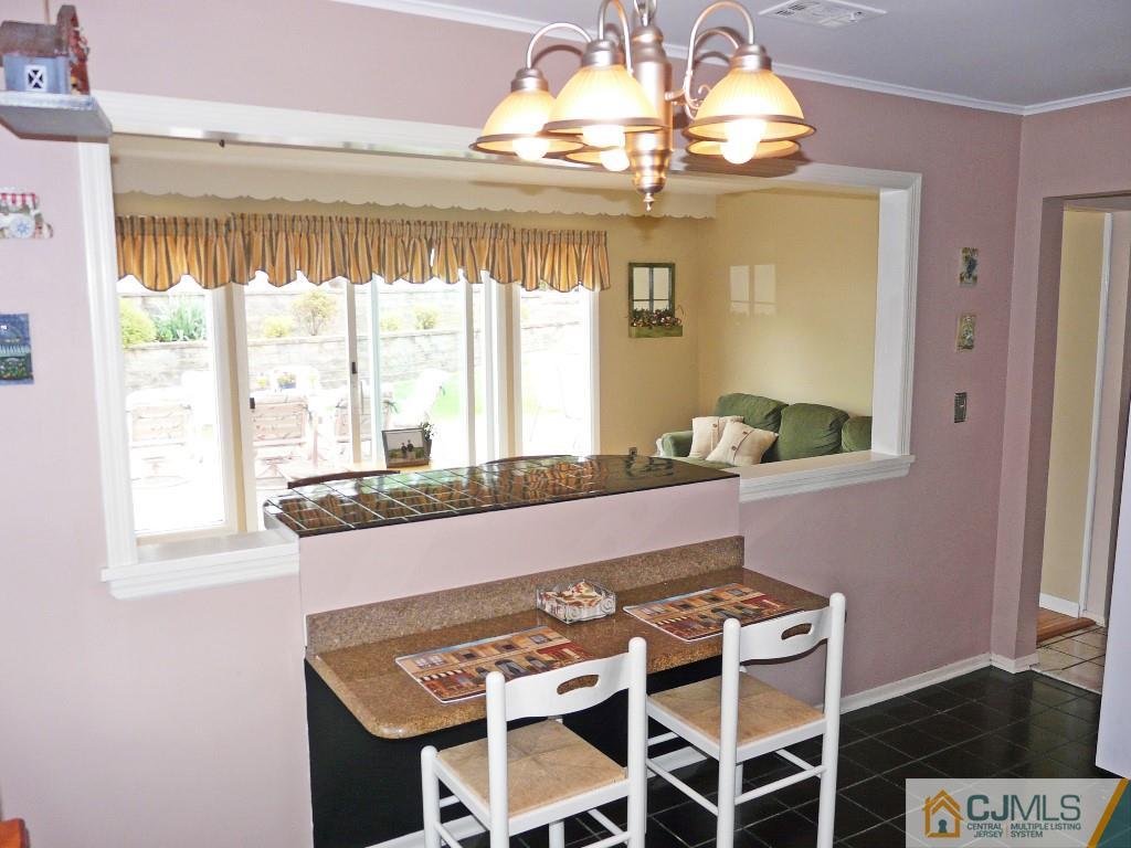 90 Drake Road Somerset, NJ 08873 - Photo 8 of 20 a dining room with wooden floor a chandelier a wooden table and chairs