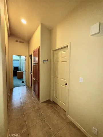 a view of a hallway with wooden shelves