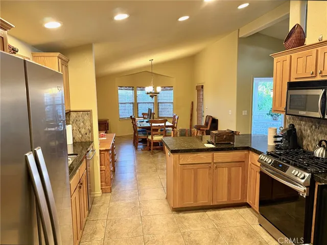 a kitchen with stainless steel appliances granite countertop a sink a stove and a refrigerator