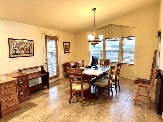 a view of a dining room and livingroom with furniture wooden floor a rug and a painting