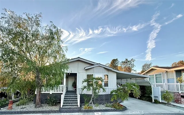 a view of a house with a yard and potted plants