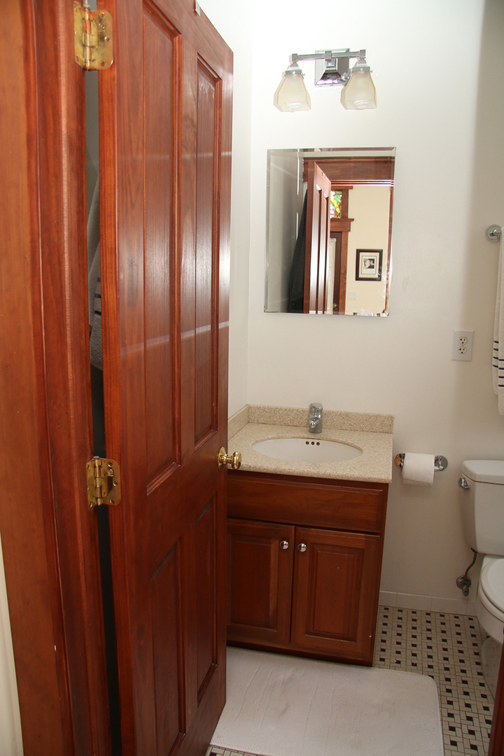 857 West Newport Avenue, Unit 3 Chicago, IL 60657 - Photo 11 of 19 a bathroom with a granite countertop sink and a mirror