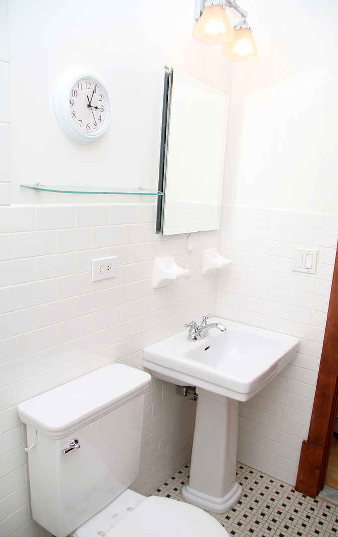 857 West Newport Avenue, Unit 3 Chicago, IL 60657 - Photo 14 of 19 a bathroom with a sink a mirror and a toilet