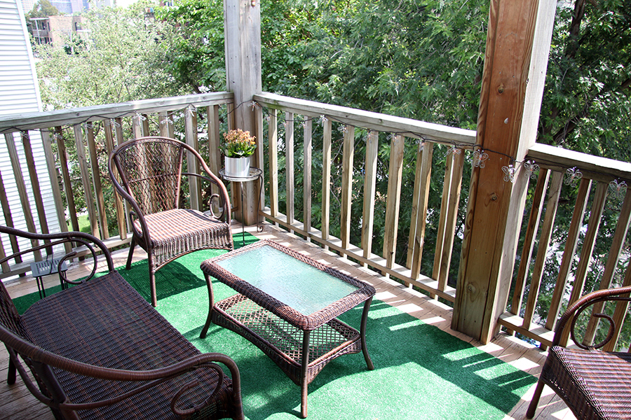 857 West Newport Avenue, Unit 3 Chicago, IL 60657 - Photo 18 of 19 a balcony with wooden floor outdoor seating and yard in the back