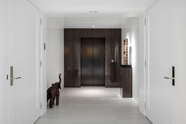 a view of a hallway with closet and a bathroom