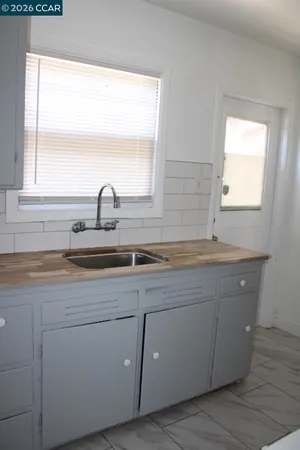 a sink with a granite countertop window and a sink