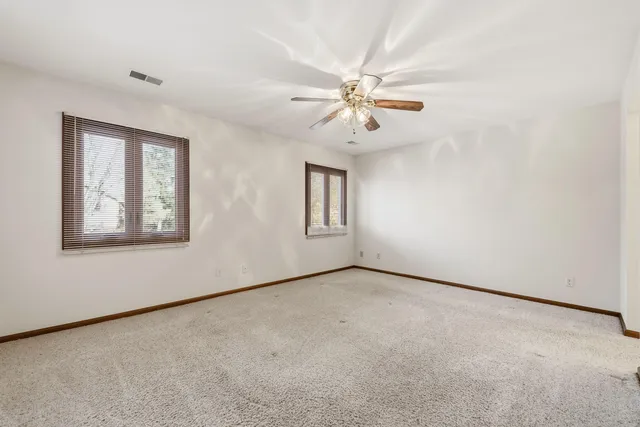 a view of an empty room with chandelier fan
