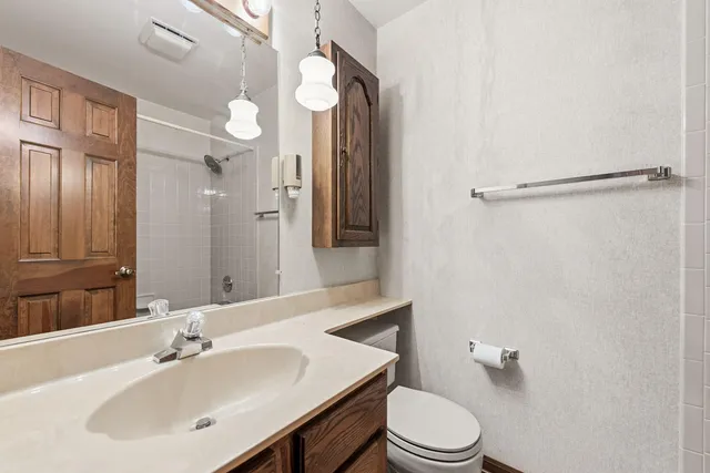 a bathroom with a sink a toilet and shower