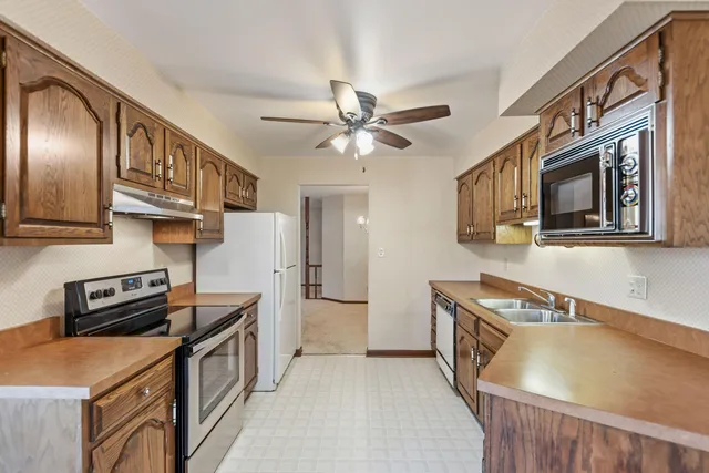 a kitchen with stainless steel appliances a stove a sink and a refrigerator
