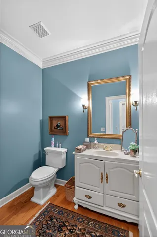 a bathroom with a granite countertop sink and a toilet