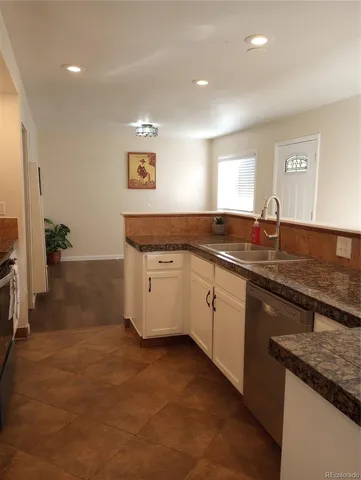 a kitchen with granite countertop a sink and cabinets