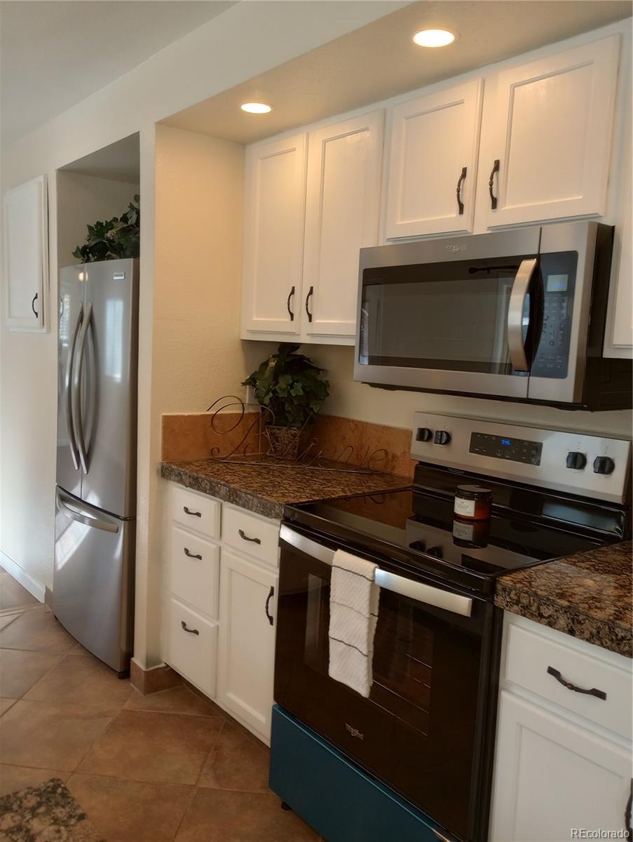 111 Crystal Park Road, Unit 1 Manitou Springs, CO 80829 - Photo 6 of 28 a kitchen with granite countertop a stove and a microwave