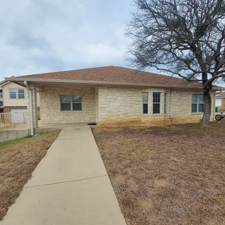 a front view of house with yard and trees around