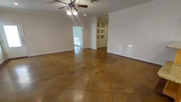 a view of an empty room with a chandelier fan