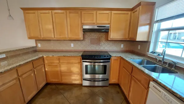 a kitchen with granite countertop a sink and cabinets