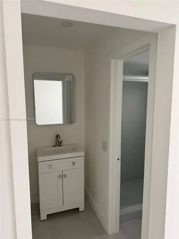 a en suite bathroom with a sink vanity and mirror
