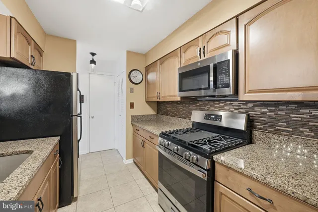 a kitchen with stainless steel appliances granite countertop a sink stove and microwave