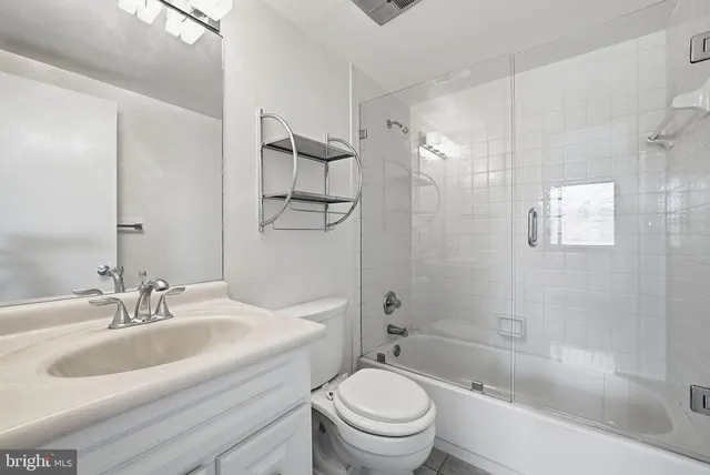 an empty room with wooden floor and mirror