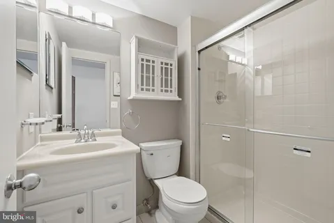 a bathroom with a sink a mirror a toilet and shower