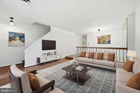 a living room with furniture a flat screen tv and a window