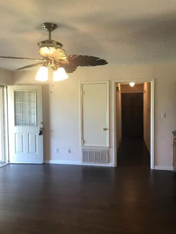a view of a livingroom with a ceiling fan and window