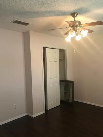 an empty room with windows and fan