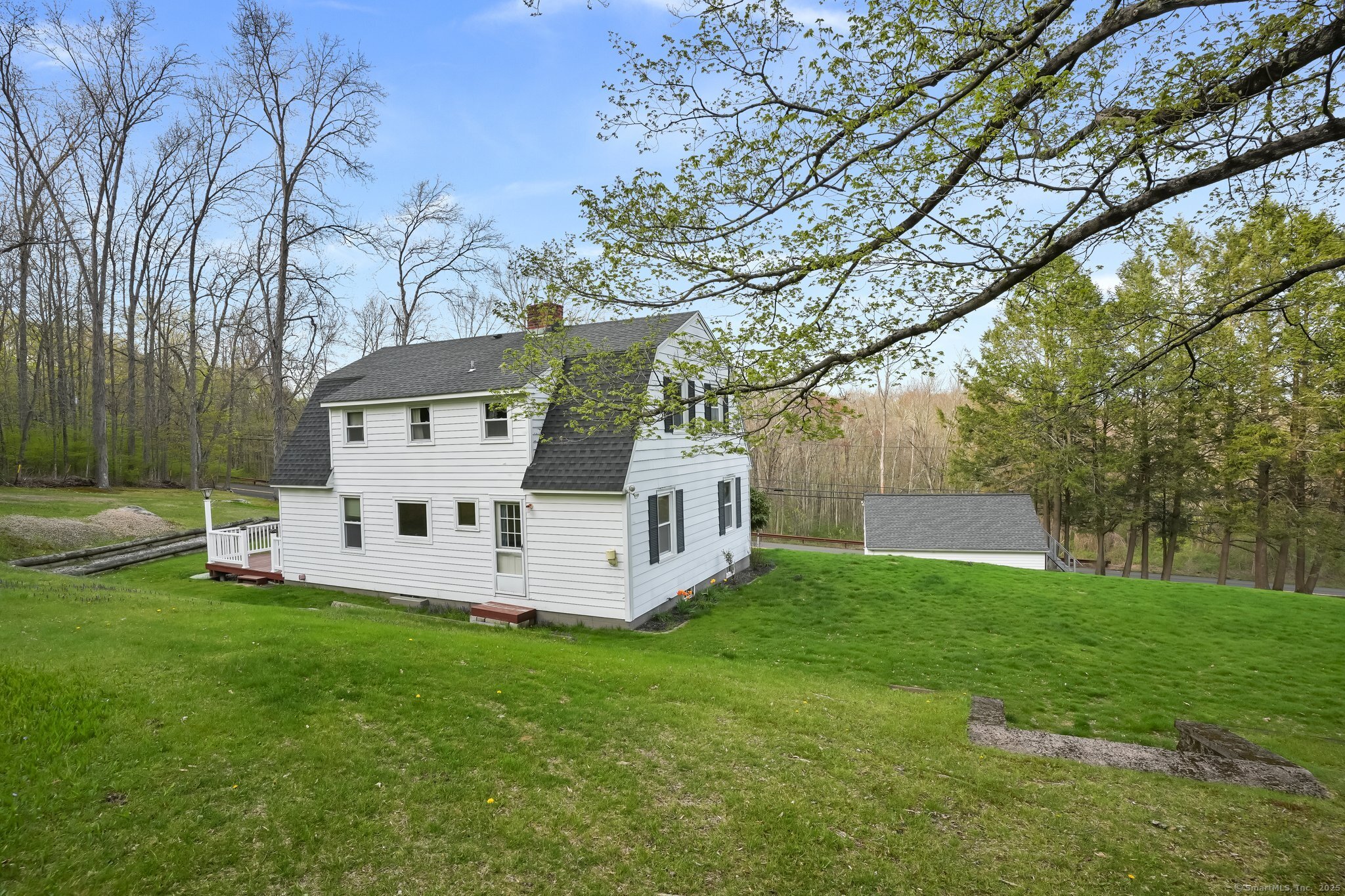 a white house that has a tree in a field