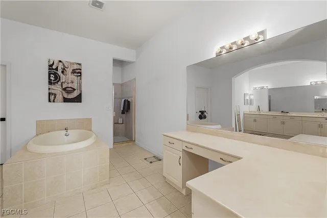 a bathroom with a tub sink and mirror