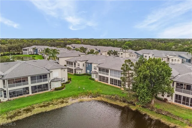 a view of a house with a yard and large tree
