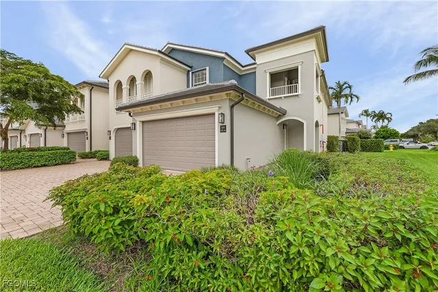 a view of white house with a yard and potted plants