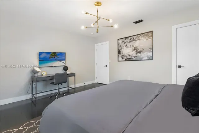 a bedroom with a bed and a chandelier