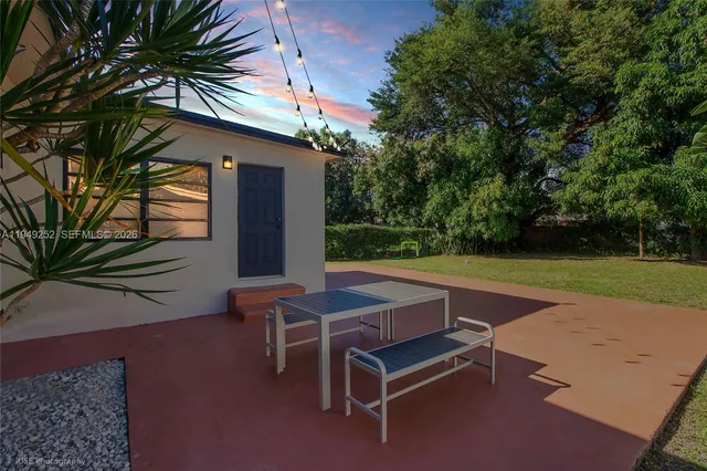 a backyard of a house with yard and outdoor seating