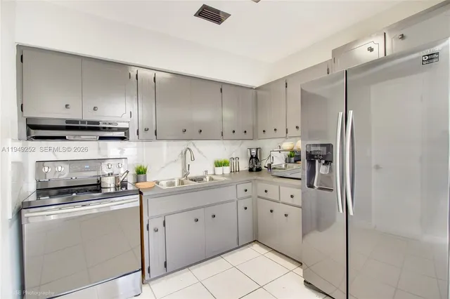 a kitchen with cabinets stainless steel appliances and a counter space