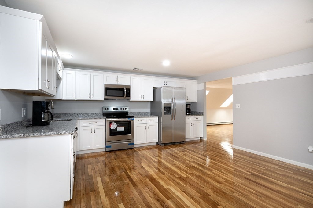 213 Beaver Dam Road Scituate, MA 02066 - Photo 24 of 28 a kitchen with stainless steel appliances granite countertop a stove a sink and a refrigerator