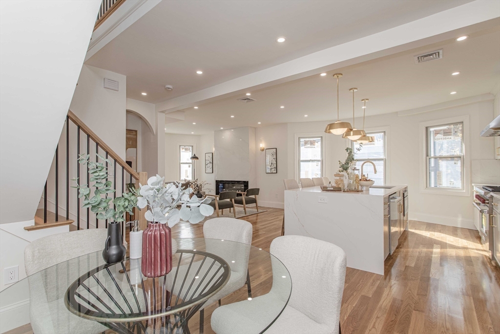 125 Mt Vernon Street, Unit 2 Newton, MA 02465 - Photo 11 of 36 a dining room with furniture a kitchen and chandelier