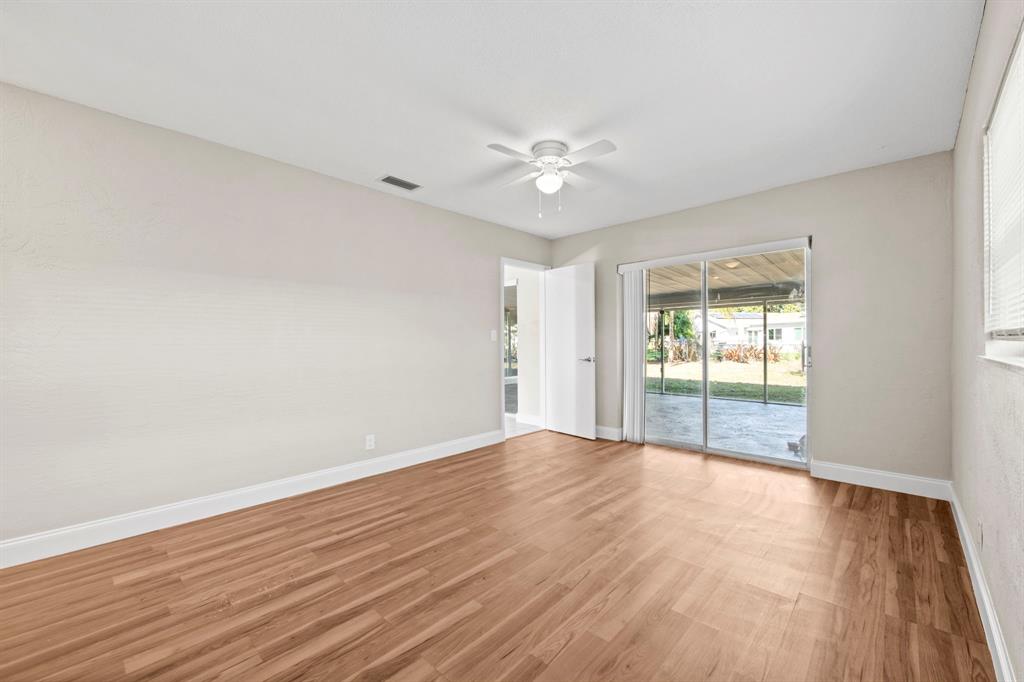 9203 Northwest 71st Street Tamarac, FL 33321 - Photo 14 of 23 a view of an empty room with wooden floor and a window