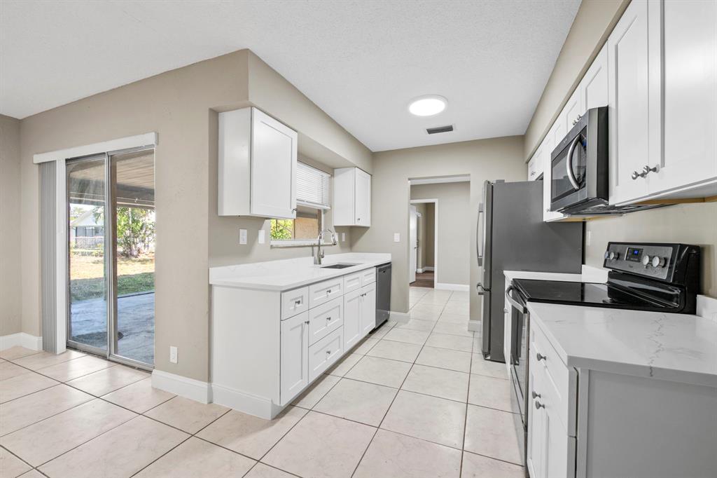 9203 Northwest 71st Street Tamarac, FL 33321 - Photo 4 of 23 a kitchen with stainless steel appliances granite countertop a stove a sink and a refrigerator