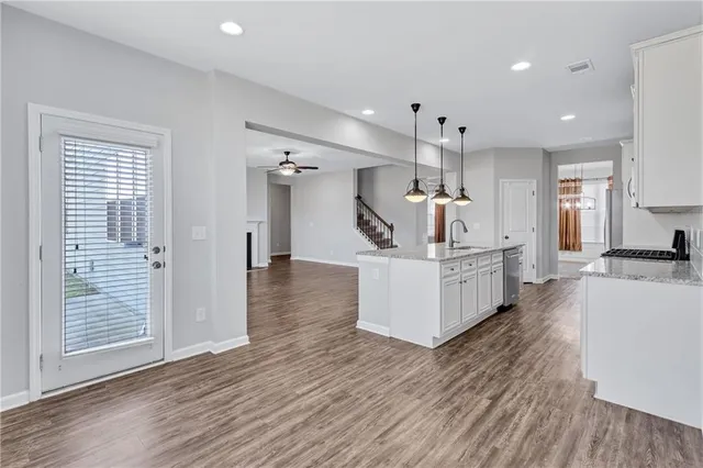 a kitchen with wooden floors and white cabinets