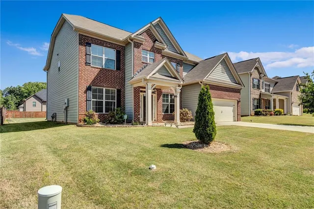 a front view of a house with a garden