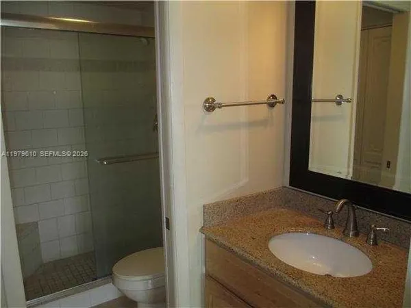 a bathroom with a granite countertop sink toilet and shower