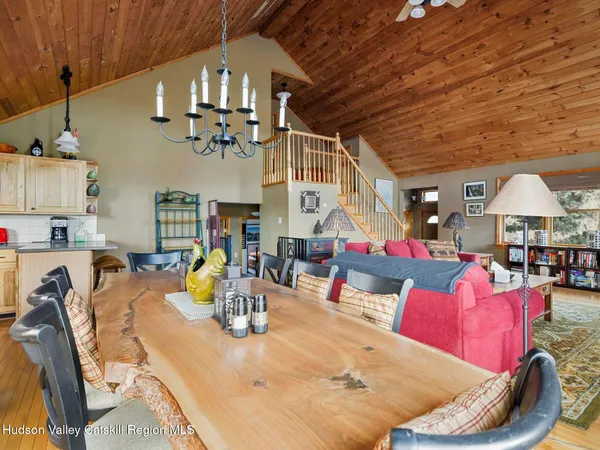 a dining room with stainless steel appliances a dining table and chairs with wooden floor