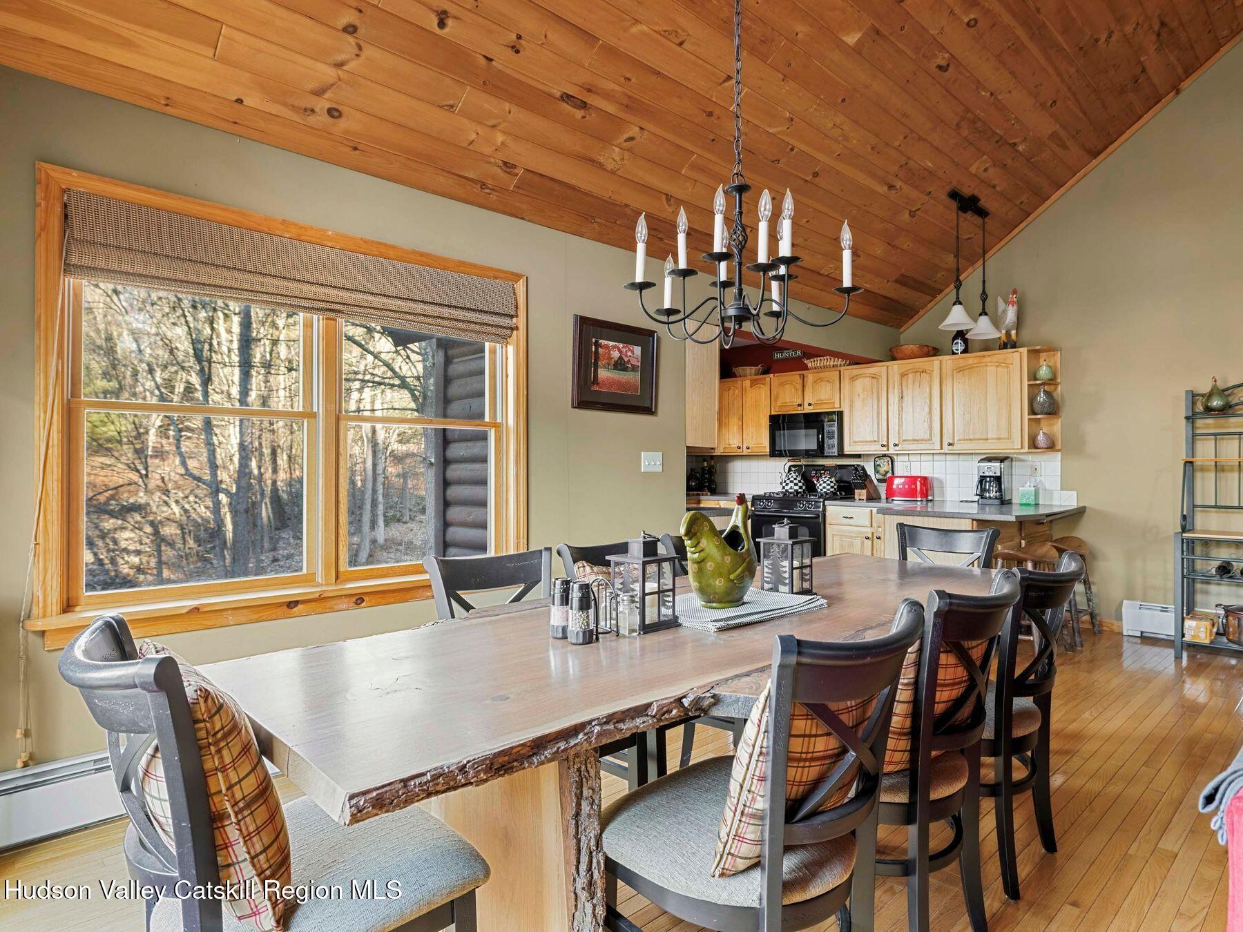 83 Lawrence Road Jewett, NY 12442 - Photo 15 of 52 a dining room with stainless steel appliances a dining table and chairs with wooden floor