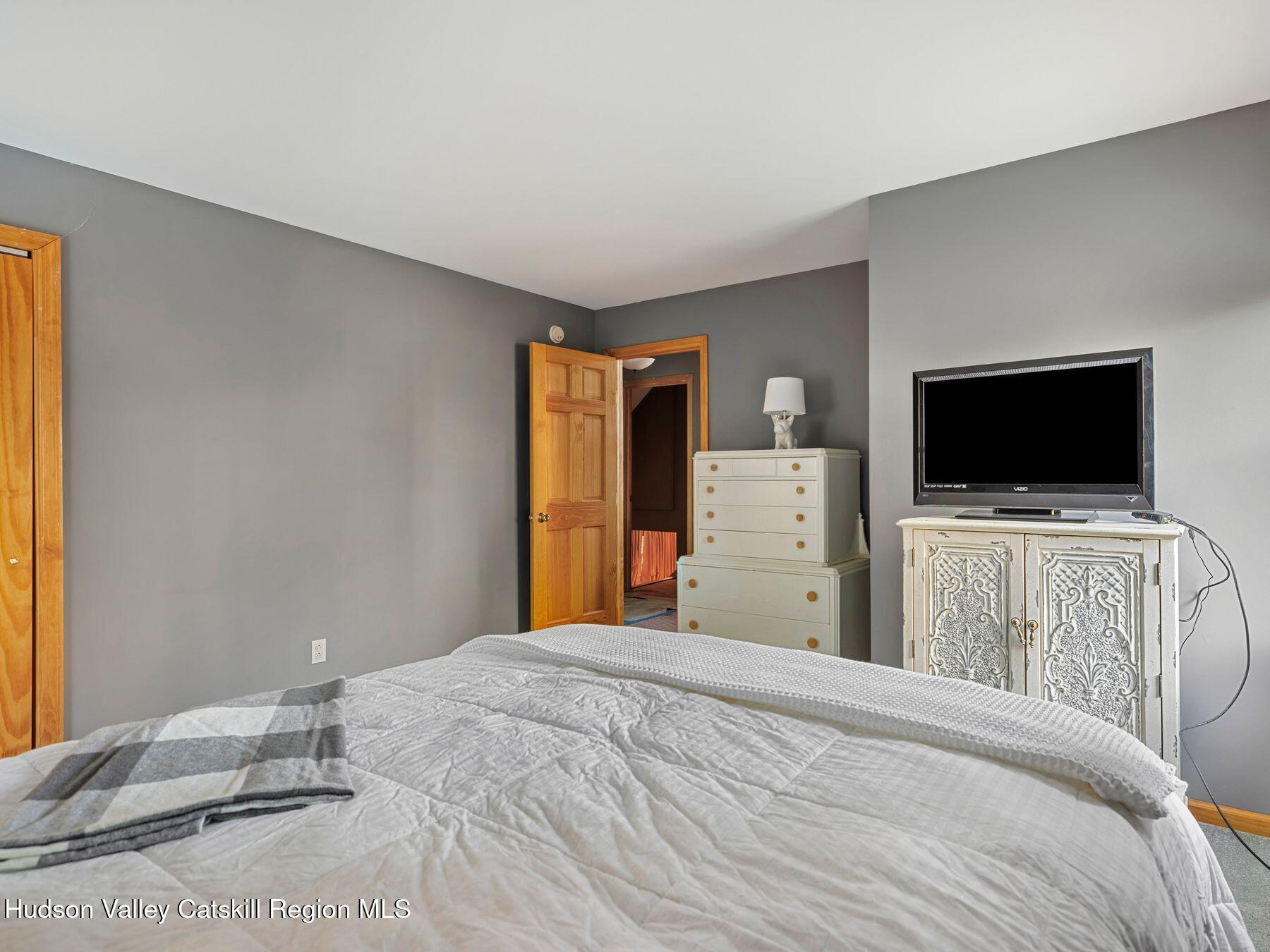 83 Lawrence Road Jewett, NY 12442 - Photo 21 of 52 a bedroom with a bed and a flat screen tv