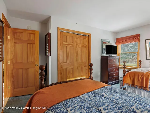 a bedroom with a bed lamp and a large window